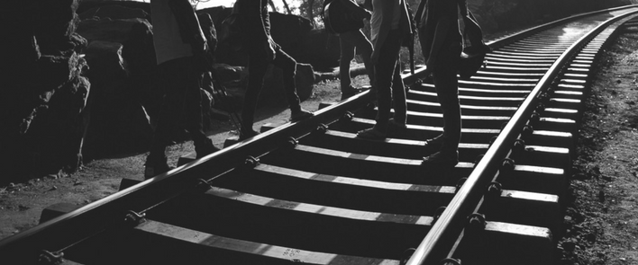 Folks walking on the railroad tracks